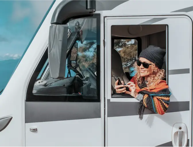 Woman leaning out the driver's side door of an RV